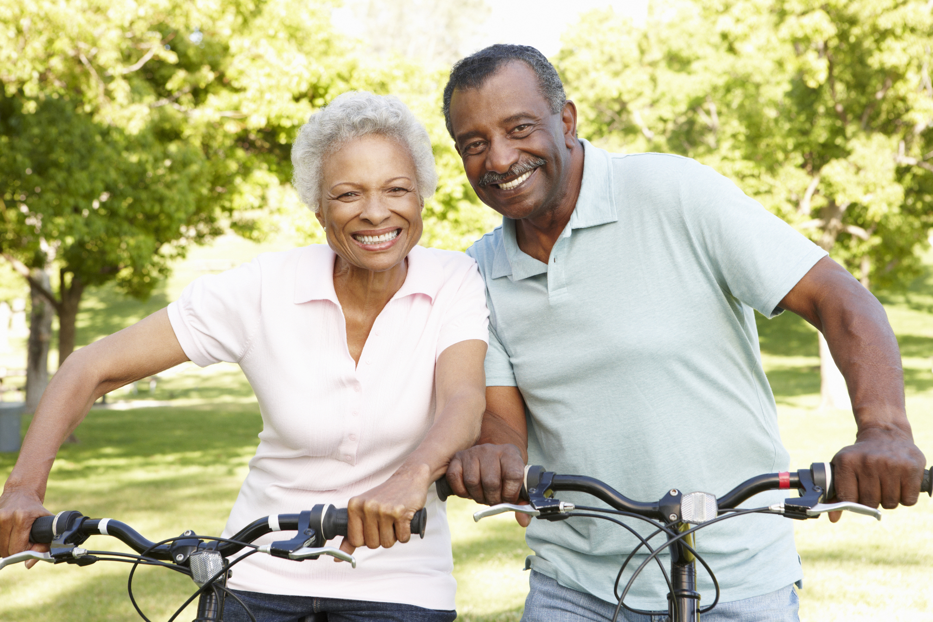 An active couple on bicycles in a leafy park