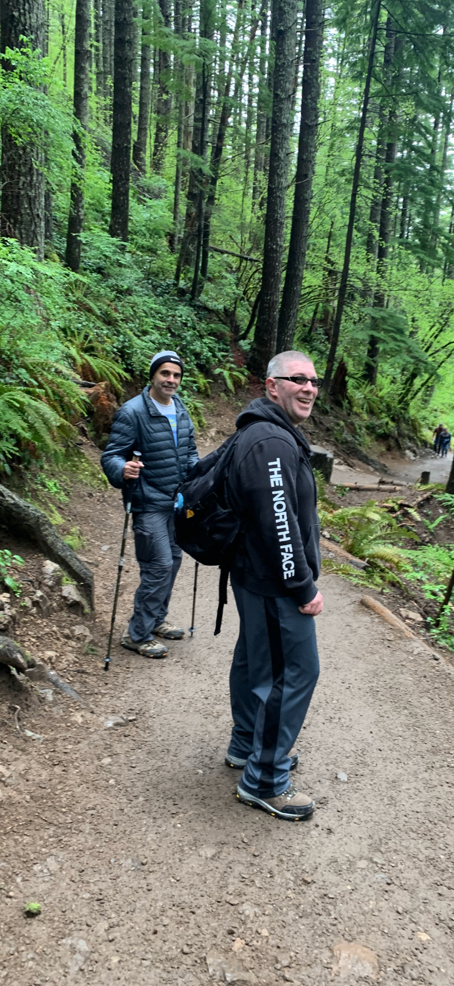 Ned hiking a forested trail with a friend