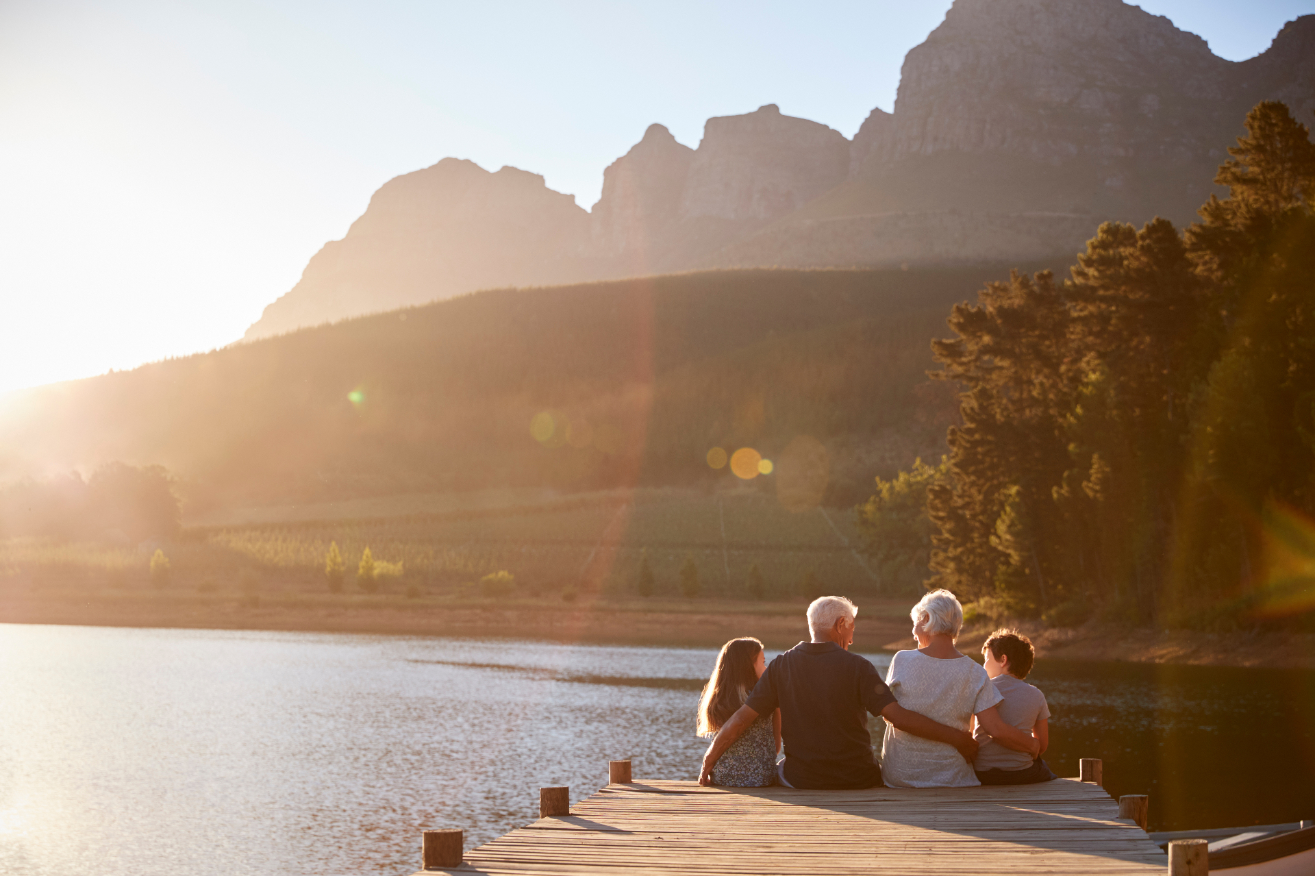 Grandparents and grandchildren on a dock at golden hour